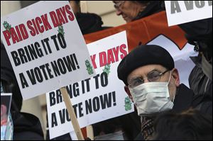 Activists hold signs during a rally at New York's City Hall to call for immediate action on paid sick days legislation in light of the continued spread of the flu. An unusually early and vigorous flu season is drawing attention to the cause that has both scored victories and hit roadblocks in recent years: mandatory paid sick leave.