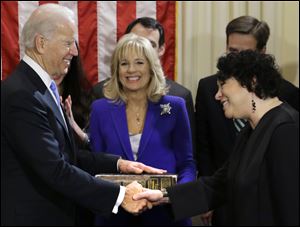 Vice President Joe Biden, with his wife, Jill Biden, center, holding the family Bible, shakes hands with Justice Sonia Sotomayor after taking his oath of office.