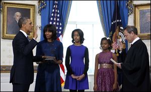 President Barack Obama is officially sworn-in by Chief Justice John Roberts in the Blue Room of the White House during the 57th Presidential Inauguration today. Next to Obama are first lady Michelle Obama, holding the Robinson Family Bible, and daughters Malia and Sasha.