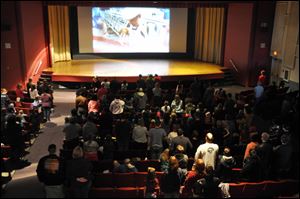 Some 250 people stand for the playing of the national anthem ahead of a showing of 