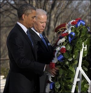 President Obama and Vice President Joe Biden place a wreath at the Tomb of the Unknowns on Sunday at Arlington National Cemetery in Arlington, Va.