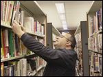  Eric Perron of Toledo, in the Sylvania Branch library, looks for books on basement refinishing.  Patrons of newly reopened library branches are happy to see the  reinstatement of Sunday hours.