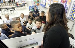 Peggy Belcher reads a story to her second-grade class at  the Martin Luther King, Jr.,  Academy for Boys. Students Marvon Wadley, left, and Caden Hattfield, right, point out details in the story.