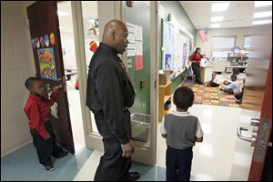 Principal Willie Ward escorts two kindergartners back to class after talking with them about proper behavior.