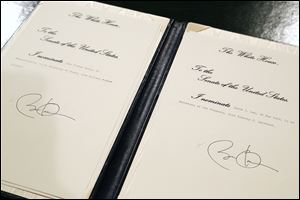 Nominations for Sen. John Kerry (D., Mass.) to be named Secretary of State, left, and for White House Chief of Staff Jacob Lew to be named Treasury Secretary, right, bear President Obama's signature after the president  signed them on Capitol Hill in Washington today.
