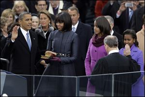 President Obama receives the oath of office from Chief Justice John Roberts at the ceremonial swearing-in at the U.S. Capitol during the 57th Presidential Inauguration. First Lady Michelle Obama holds the bible as daughters Malia and Sasha watch. 