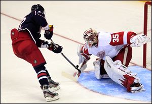 Detroit Red Wings' Jimmy Howard, right, makes a save against Columbus Blue Jackets' Artem Anisimov, of Russia, during the shootout of an NHL hockey game. The Red Wings won 4-3.