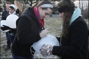 Julia Debelly and Shayna Zack write a joint message to Morgan Duris on a balloon. Three years ago Morgan Duris, 15, was killed while crossing the street to get on her school bus. Her friends gathered at Northview Hill to release balloons in her memory.