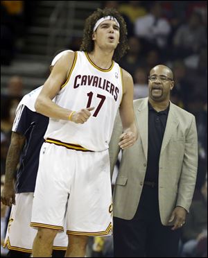 Cleveland Cavaliers' Anderson Varejao (17), from Brazil, grimaces after hitting the floor during an NBA basketball game against the Toronto Raptors in Cleveland.