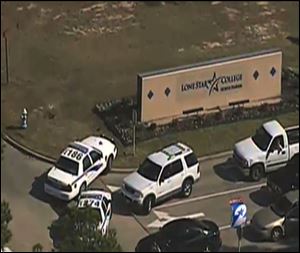 In this frame grab provided by KPRC Houston, police vehicles block an entrance to Lone Star College in Houston, where law enforcement officials say the community college is on lockdown amid reports of a shooter on campus.