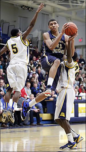 Whitmer's Jon Ashe, right, tries to thwart St. John's Marc Loving's trip to the basket while Chris Parker (5) attempts a block in Tuesday's contest in the Whitmer Fieldhouse. The visiting Titans won 52-51.