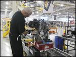  An employee adds an engine’s electrical harness at Chrysler’s Dundee Engine Plant. Chrysler chose to eliminate one of the plant’s shifts after somewhat disappointing sales of the Dodge Dart and Fiat 500. 