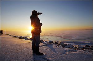ROV frozen25p    Christopher Jenkins enjoys a cup of coffee and the sunrise over Lake Erie as he scans the horizon for wildlife on a frigid morning at Luna Pier, Mi., Thursday, January 24, 2013.  The Blade/Andy Morrison