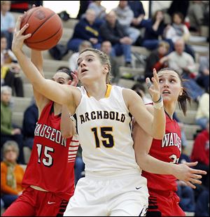 Archbold's Cassidy Wyse (15) goes to the net against  Wauseon's Sariah Yackee (15) and Alyssa Reed (21).