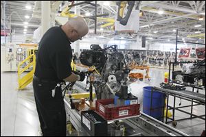 An employee adds an engine’s electrical harness at Chrysler’s Dundee Engine Plant. Chrysler chose to eliminate one of the plant’s shifts after somewhat disappointing sales of the Dodge Dart and Fiat 500. 