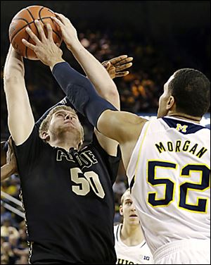 Jordan Morgan, right, blocks a shot by Purdue’s Travis Carroll during  Michigan’s win.