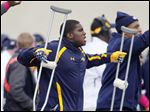  Former University of Toledo football player T.J. Fatinikun supports his teammates from the sideline last season.
