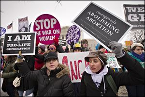 Anti-abortion activists and supporters of legal abortion stand in front of the Supreme Court in Washington on the 40th anniversary of the Roe v. Wade decision.