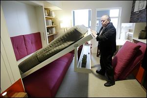 Jack Sproule tries out a fold-down bed in a 325 square foot model apartment at an exhibit called 
