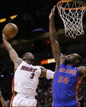 Miami Heat guard Dwyane Wade goes up for a shot against Detroit Pistons forward Jason Maxiell tonight in Miami.