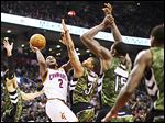  The Cavaliers' Kyrie Irving (2) shoots against the Raptors' Landry Fields, left, Kyle Lowry (3), and Amir Johnson (15) during the first half.