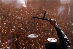An Egyptian soccer fan of Al-Ahly club displays scales to fans celebrating a court verdict that returned 21 death penalties in last year's soccer violence, inside the club premises in Cairo.