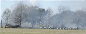 A fire set by a man suspected of fatally shooting a police officer and critically wounding two sheriff's deputies is extinguished, today in Charenton, La. 