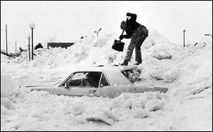 Toledoan Jerry Ludwig attempts to dig his car out of a snow pile at the Glenbyrne Shopping Center parking lot.