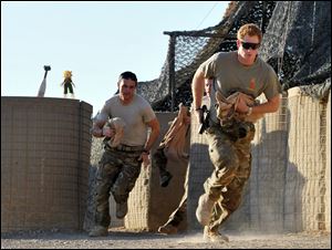 Britain's Prince Harry, right, or just plain Captain Wales as he is known in the British Army, races out from the VHR (very high readiness) tent to scramble his Apache with fellow pilots, during his 12-hour shift at the British-controlled flight-line in Camp Bastion southern Afghanistan in November, 2012.
