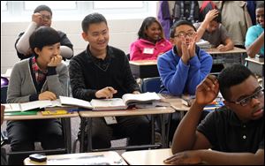 Chinese students, from left, Yuan Wang, Zhoushan Liu, and Jianheng Ma listen in Mr. Pen Tsou's eighth-grade class at Old Orchard Elementary School in Toledo.