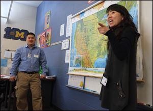 Pen Tsou, an eighth-grade teacher at Old Orchard Elementary School in Toledo, left, and Xing Xu Wang, a teacher from the Fushun Experimental Middle School in China, talk about geography in Mr. Tsou's class.  A group of Chinese students and educators are visiting Old Orchard. 