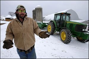 Shawn Georgetti pauses on his 167 acre family dairy farm, Saturday in Avella, Pa. With royalties from a Range Resources gas well on his property Georgetti has been able to buy newer farm equipment that's bigger, faster, and more fuel-efficient.
