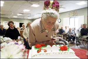 On the occasion of her 100th birthday observance Wednesday, Emma Bonawitt blows out the candles on her centennial celebration cake with friends and family at Senior Star at West Park Place in Toledo. She credits her longevity partially to not smoking. Friends and family say it’s because she’s humble.