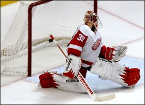 Detroit Red Wings goalie Jimmy Howard watches as a goal by Chicago Blackhawk Nick Leddy trickles into the net during overtime game Sunday in Chicago. The Red Wings lost 2-1.