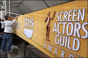Workers set up signage on the red carpet, Saturday, before the 19th annual SAG Awards Sunday night.