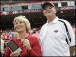  Jackie and Jack Harbaugh, parents of San Francisco 49ers coach Jim Harbaugh and Baltimore Ravens coach John Harbaugh, stand before an NFL football in 2011