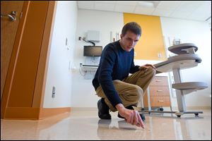 Biologist Daniel Smith swabs the floor in a new hospital room to collect microbial samples at the new University of Chicago Hospital in Chicago. The hospital is not open to the public yet.