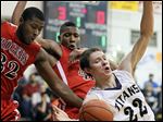  Rogers’ DeVonte Pratt, left, and Fadil Robinson, center, defend against  St. John's player Trevor Walsh during their game Tuesday night. St. John’s took control from the start and won against its former City League rival.