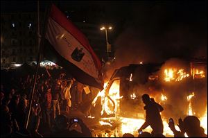 Egyptian protesters use camera phones to capture a burning state security armored vehicle that demonstrators commandeered during clashes with security forces nearby and brought to Tahrir Square and set it alight, in Cairo, Egypt, Monday.