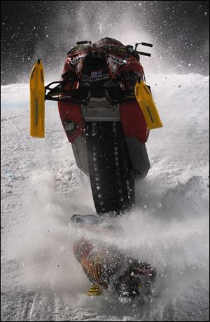 Caleb Moore was performing a flip Thursday when he clipped the top of a jump and went over the handlebars and landed face first into the snow. The snowmobile rolled over him.