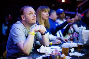 Ron Blydenburgh, of Hampton Bays, N.Y., watches the broadcast of the 2012 NFL football Super Bowl. In 2013, Super Bowl advertisers are learning the art of the tease.