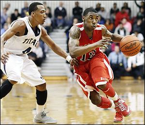 Rogers' Clemmye Owens, right, drives past  St. John's player Anthony Glover. Owens scored 19 points for the Rams while Glover had 10 for St. John's.