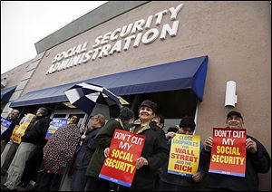 Pamela Sullivan, center, is part of a group of people organized by the AFL-CIO  protesting cuts to Social Security at the Social Security Administration building in Toledo.