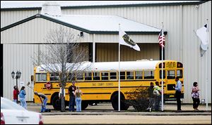 Residents look over the school bus where a shooting occurred near Destiny Church along U.S. 231, just north of Midland City, Ala. on Tuesday. 
