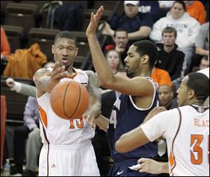 Bowling Green's A'uston Calhoun passes around the defense of Akron's Zeke Marshall during their game Wednesday night. Calhoun scored 11 points in the Falcons' home loss.
