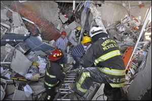 Firefighters belonging to the Tacubaya sector and workers dig for survivors after an explosion at an adjacent building to the executive tower of Mexico's state-owned oil company PEMEX today in Mexico City.