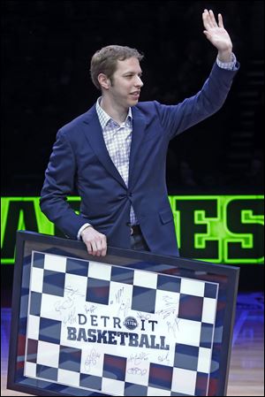 NASCAR driver Brad Keselowski waves to the crowd after receiving a plaque signed by the Detroit Pistons in honor of his 2012 NASCAR Sprint Cup Series championship.