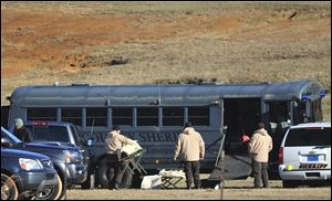 Law enforcement personnel load provisions into a bus today during the third day of a hostage crisis involving a 5-year-old boy, in Midland City, Ala.