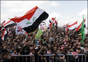 Iraqis chant anti-government slogans as they wave national flags and hold posters of slain protesters in Fallujah, 40 miles west of Baghdad, Iraq.