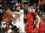  Bowling Green’s Jordon Crawford passes in front of Ball State's Matt Kamieniecki during second half. The senior scored 19 points with eight assists after not starting his first BGSU game in 46 contests.